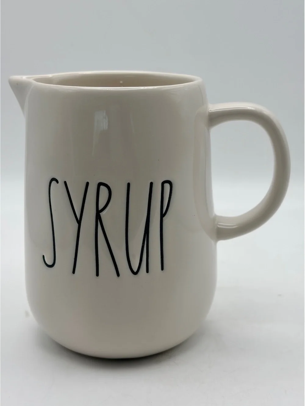 Rae Dunn white ceramic syrup pitcher.with handle. In like new condition